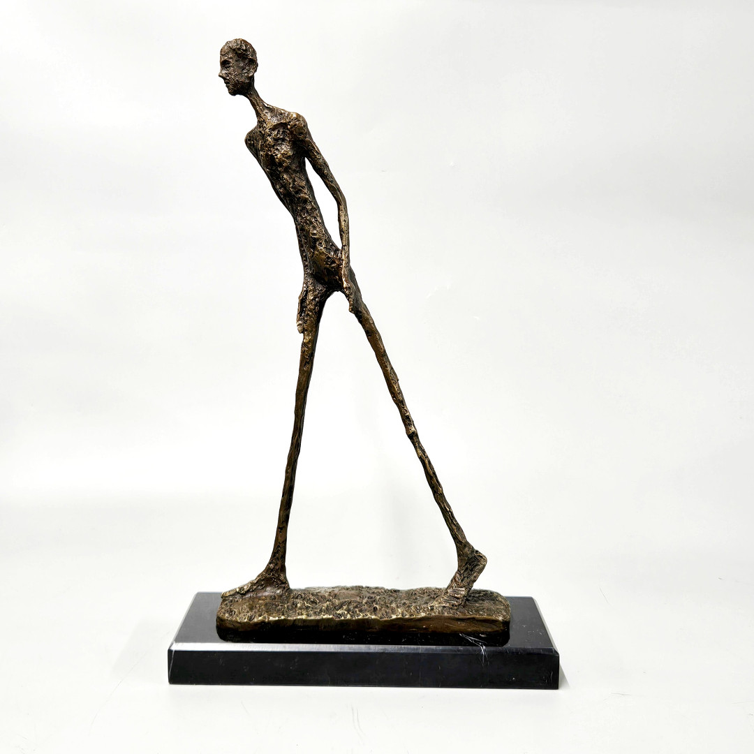 BRONZE FIGURE OF A WALKING MAN.