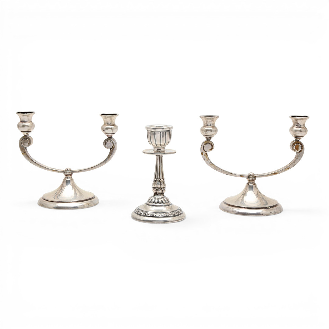 Pair of candelabra and a candlestick in silver, 20th Century.