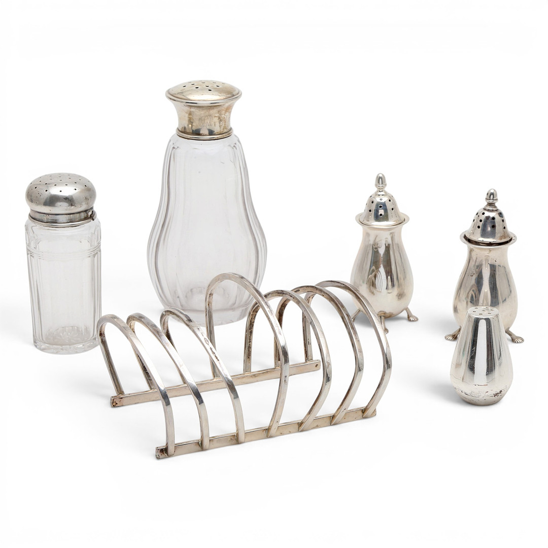 Four silver and glass salt cellars and toast rack, mid-20th century.
