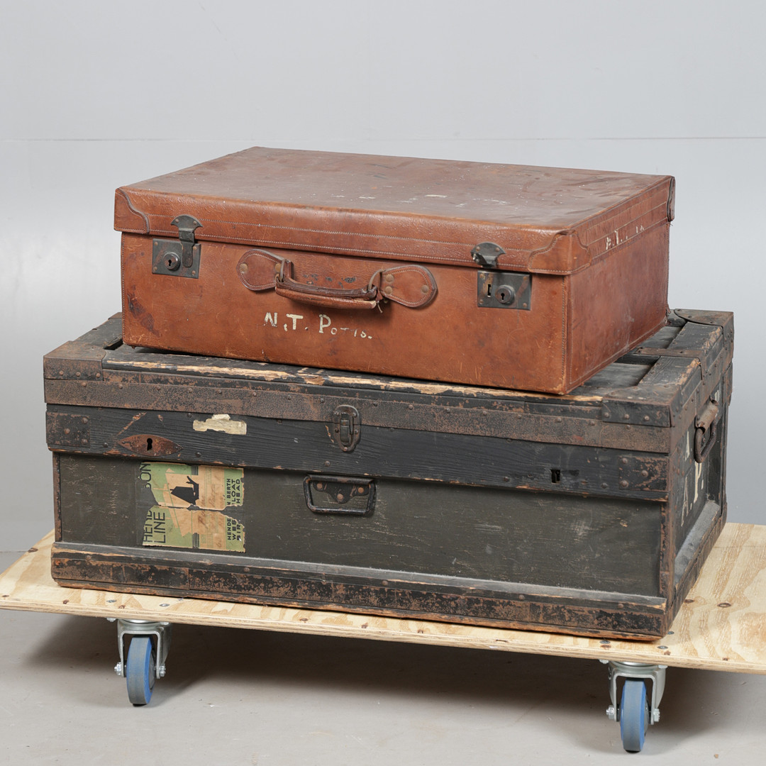 A VINTAGE METAL BOUND TRAVEL TRUNK AND A LEATHER SUITCASE.