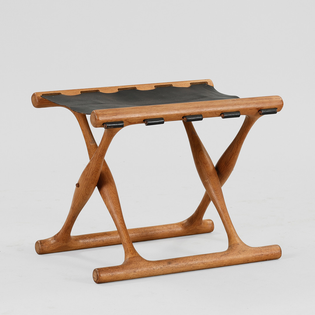 POUL HUNDEVAD. “Guldhøjstolen”, foldbar taburet med stel af eg, sæde med sort skind, model PH41, Vamdrup, Danmark, formgivet 1949.