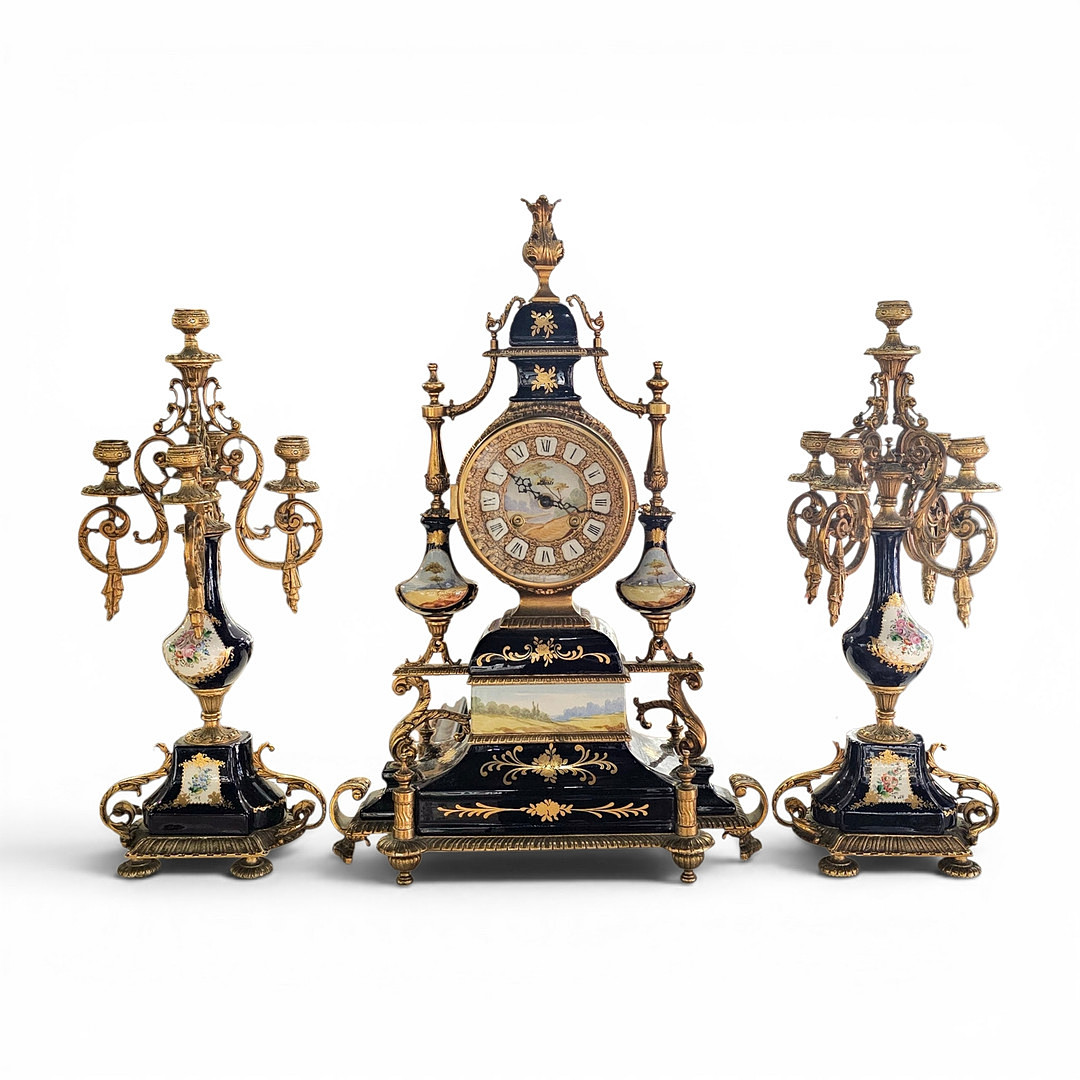 Reloj de sobremesa con guarnición de candelabros en porcelana y metal dorado. Maquinaria alemana Siglo XX.