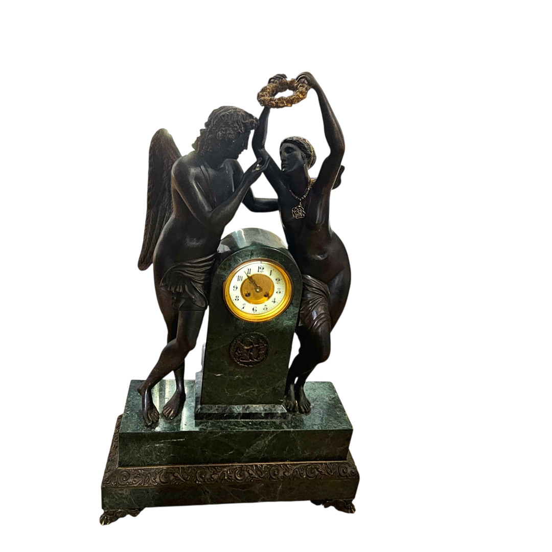Reloj de sobremesa estilo Carlos X, Francia finales Siglo XIX. "Cupido y Psyche" en mármol verde y bronce patinado. Maquinaria París.