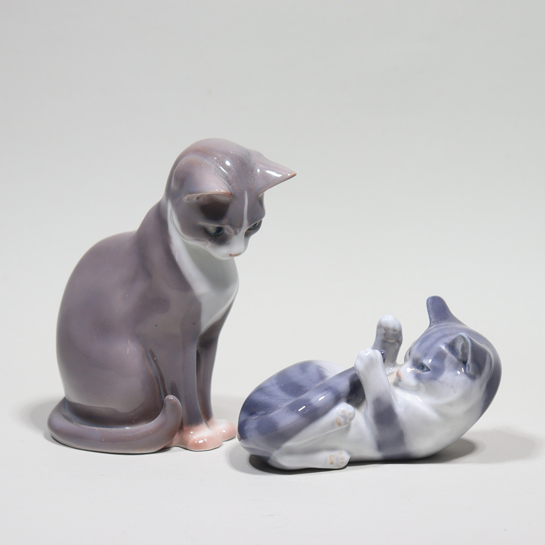 FIGURINER, Ingeborg Plockross-Irminger för Bing & Gröndahl, #1876, sittande katt samt Andrea Nielsen för Royal Copenhagen, #727, kattunge på rygg, 2 st.