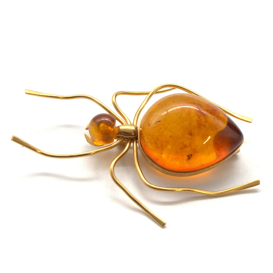 VERGOLDETE BROSCHE IN PLASTISCHER FORM EINES INSEKTS, MIT ZWEI HONIGBERNSTEIN-CABOCHON BESETZT, RUSSLAND 20. JAHRHUNDERT, PUNZIERT.
