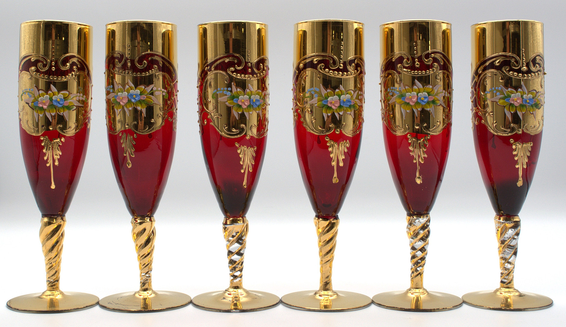 SET AUS 6 VENEZIANISCHEN CHAMPAGNERFLÖTEN, GLAS, RUBINROT, HANDBEMALT, GOLD UND BLUMENDEKOR, ITALIEN UM 1970.