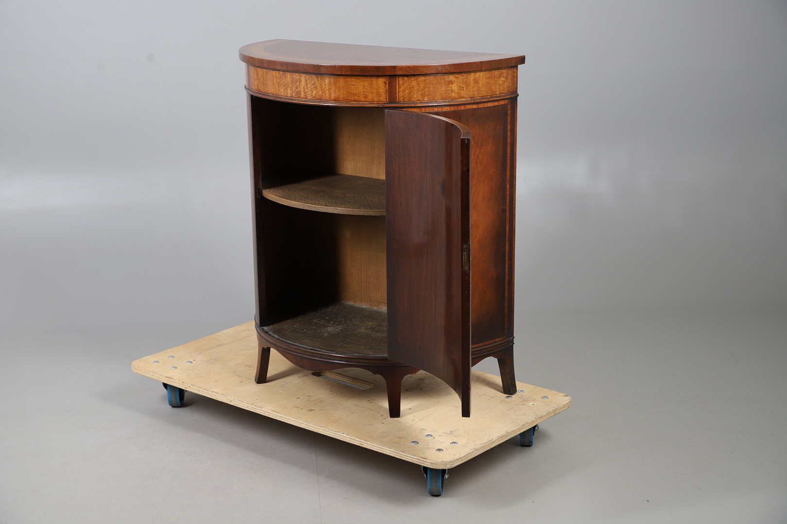 AN INLAID MAHOGANY DEMILUNE CUPBOARD.