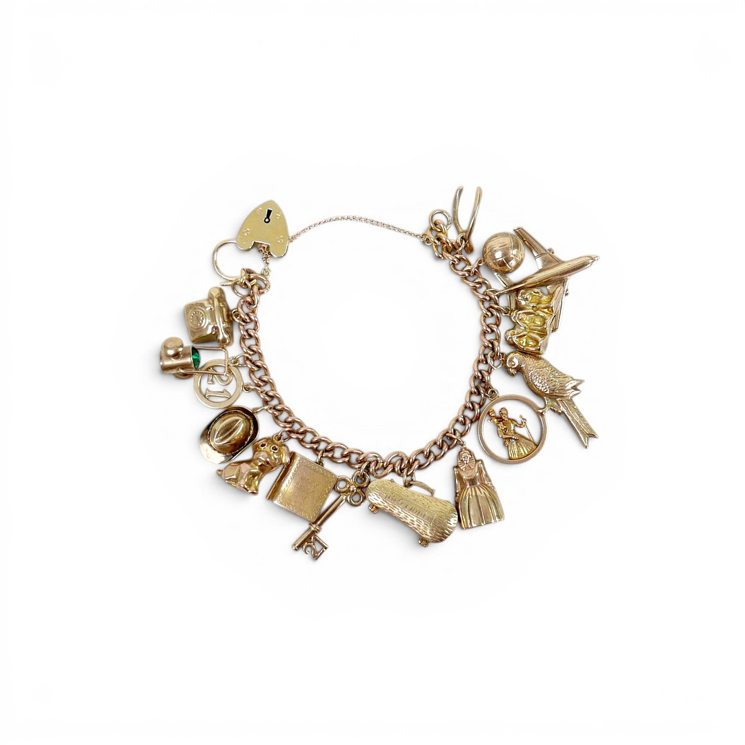 A 9CT GOLD CHARM BRACELET WITH CHARMS.