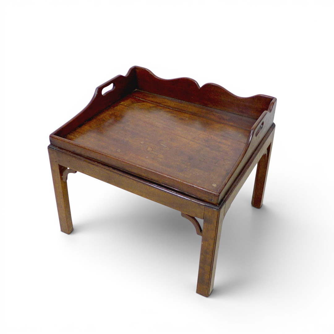 AN EDWARDIAN MAHOGANY BUTLER’S TRAY-TOP OCCASIONAL TABLE.