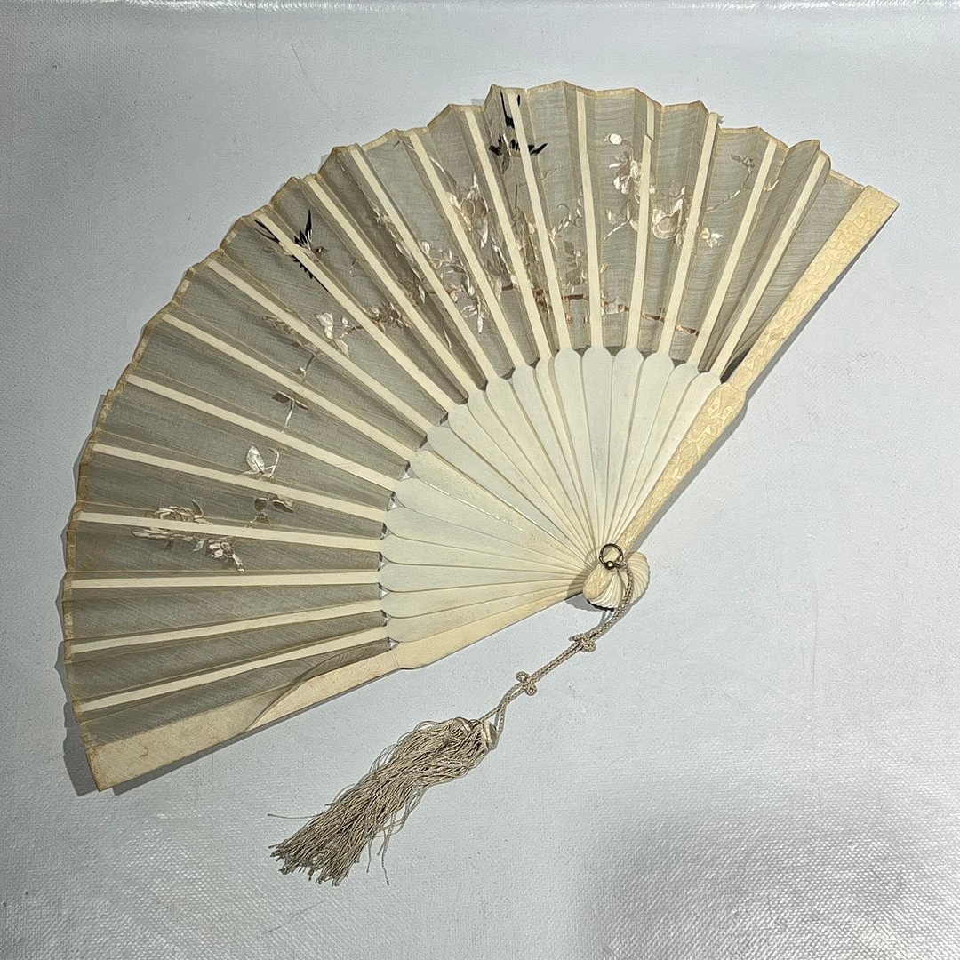 Abanico oriental en seda bordada con varillaje en hueso tallado.