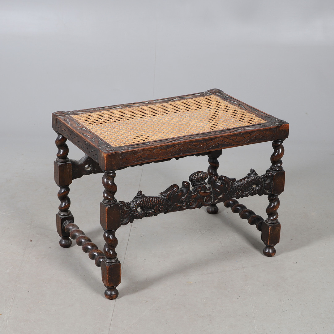 A CAROLEAN STYLE CARVED OAK DRESSING STOOL.