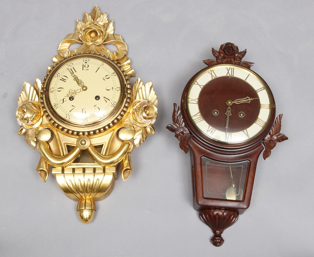 VÄGGPENDYLER, 2 st, guldfärgad samt mahogny, dekor av blommor, 1900-tal.
