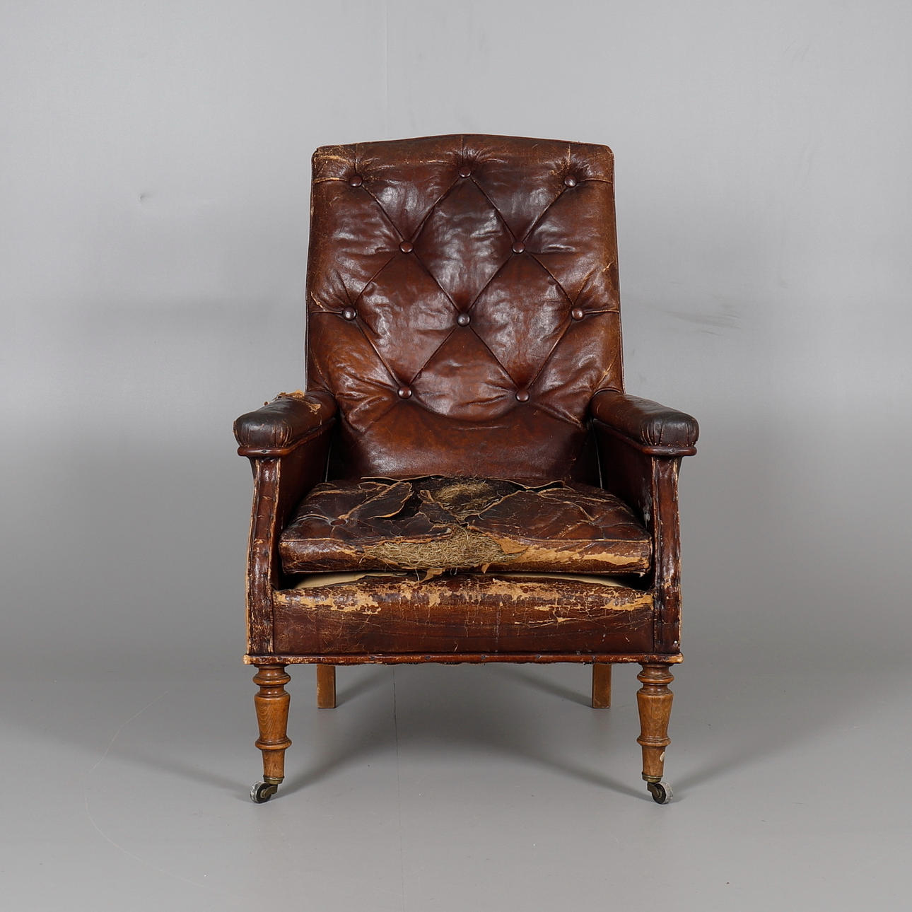 A VICTORIAN LEATHER UPHOLSTERED LIBRARY CHAIR.