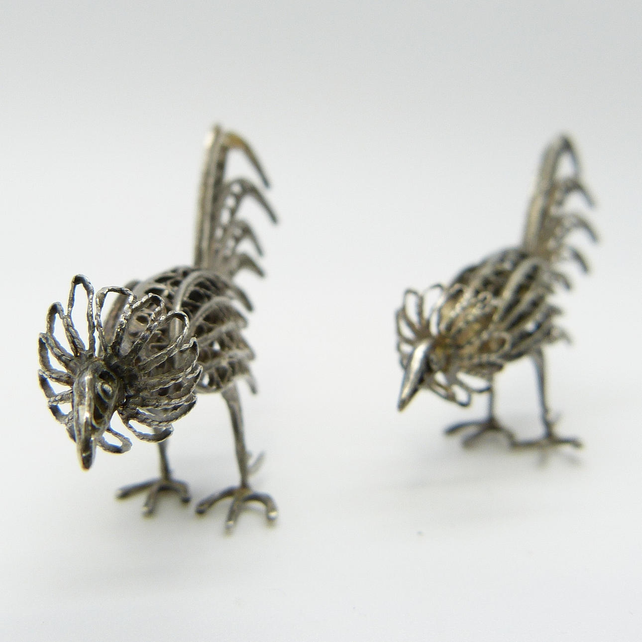 TVÅ VITA METALL PÅFÅGLAR.