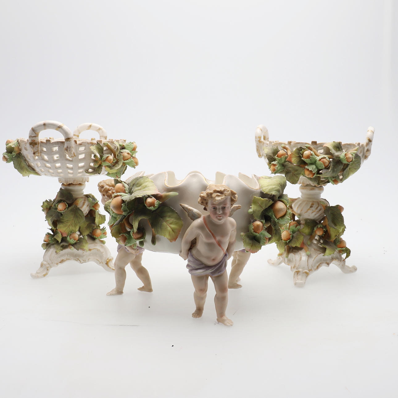 EINE SITZENDORFER TISCHGARNITUR MIT FRUCHTHASELNASEL INKRUSTIERT.