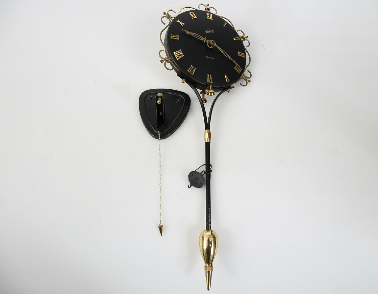 WALL CLOCK WITH PENDULUM, black and yellow metal, Schatz.