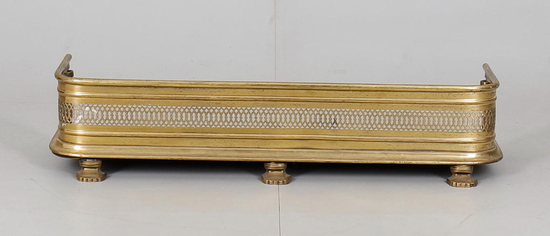 A SMALL CAST AND PIERCED BRASS FENDER.