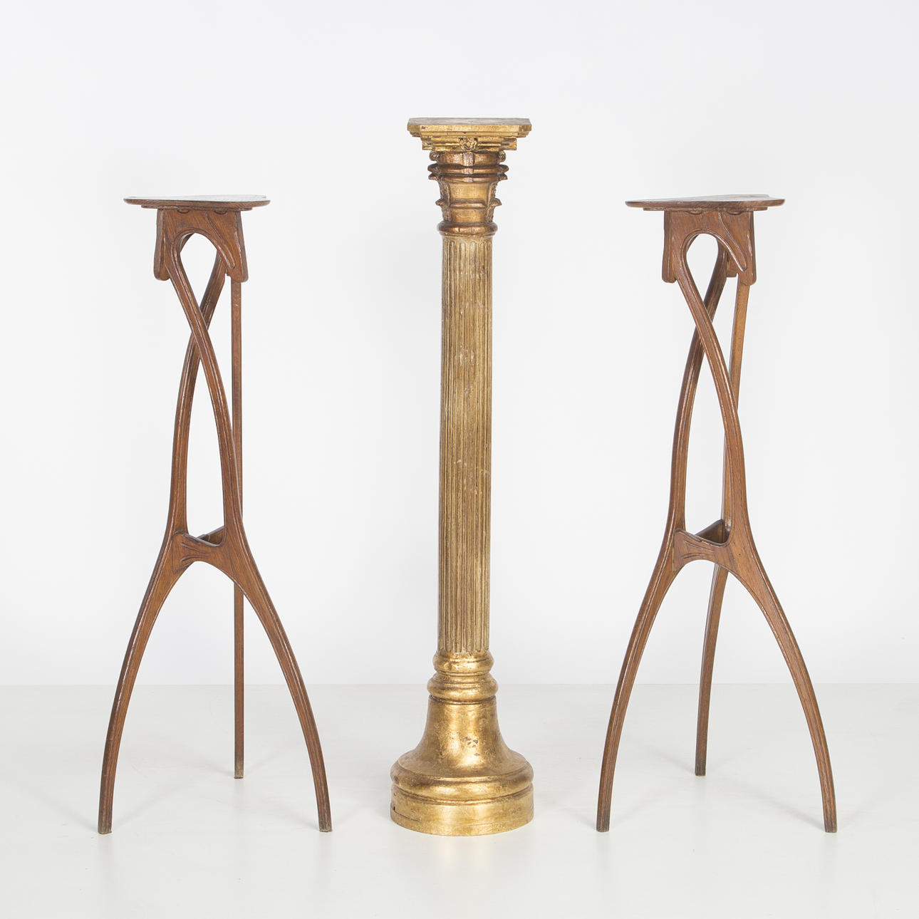 Pair of Art Nouveau-style oak stands and Corinthian stand-column in carved and gilt wood, 20th Century.