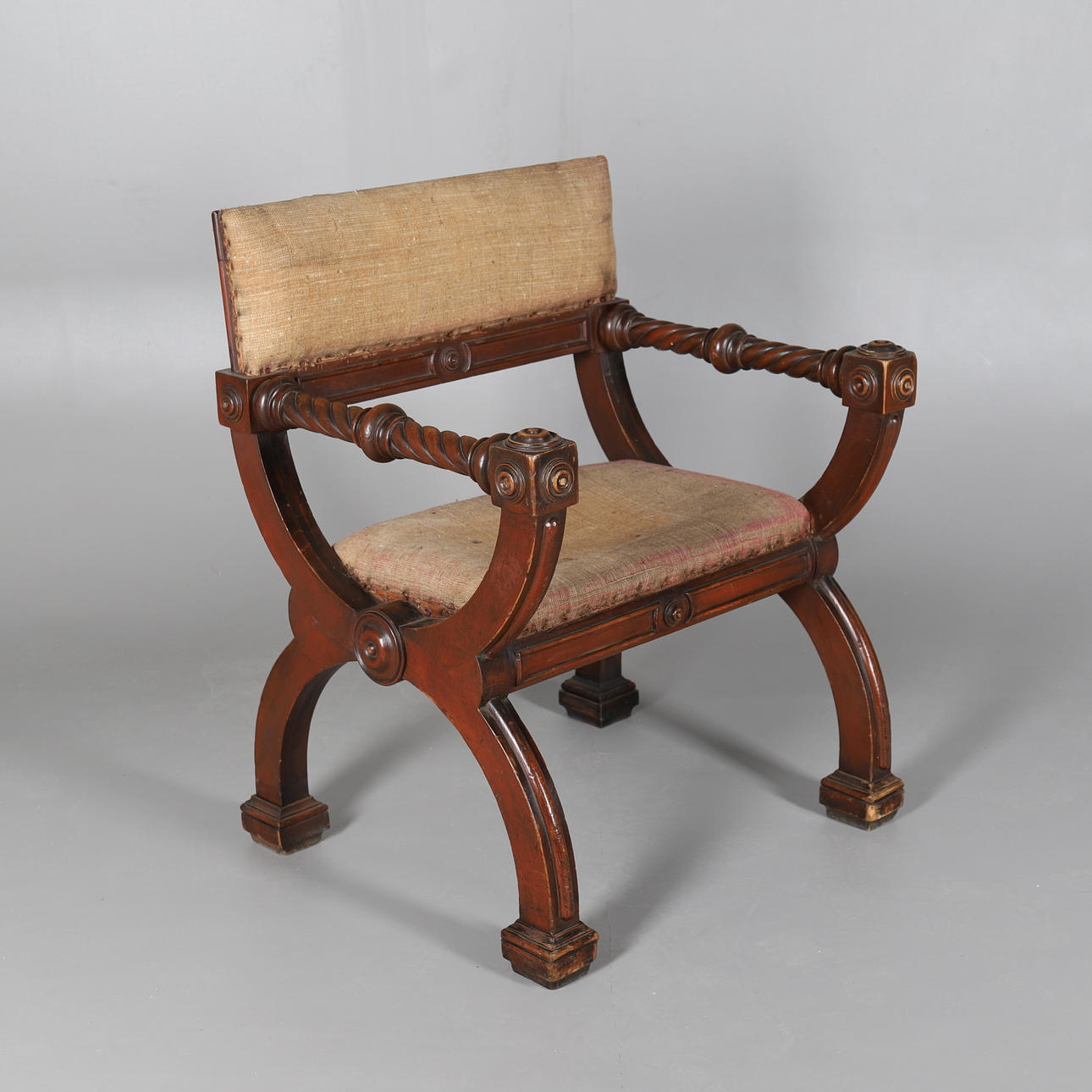 UNA SILLA ESTILO CURULE DE CAOBA.