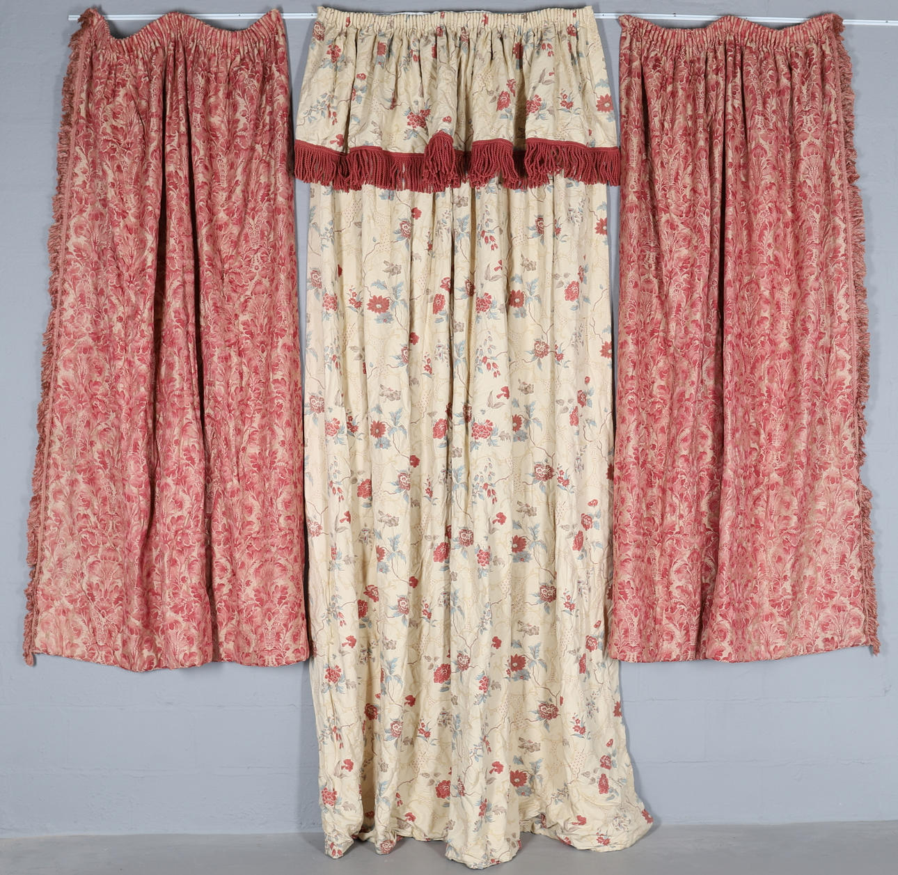 ETT PAR INTERFODRADE VÄVDA RÖDA MÖNSTRADE GARDINER MED SLADDAR.