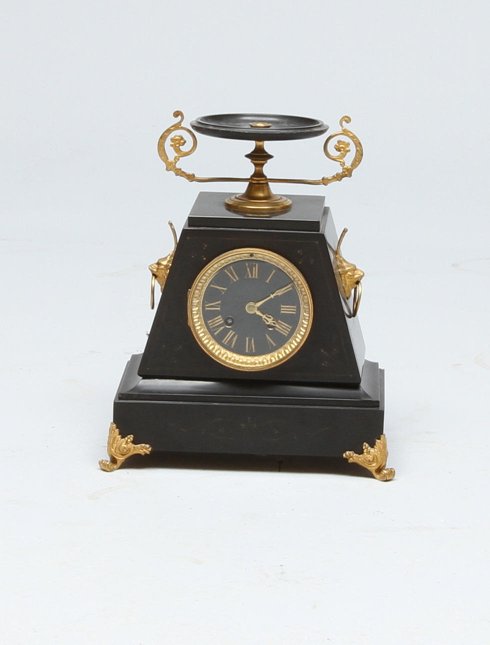 BORDSUR, svart sten, med dekor av bl a tazza samt lejonmaskaroner i mässing, 1800-tal.