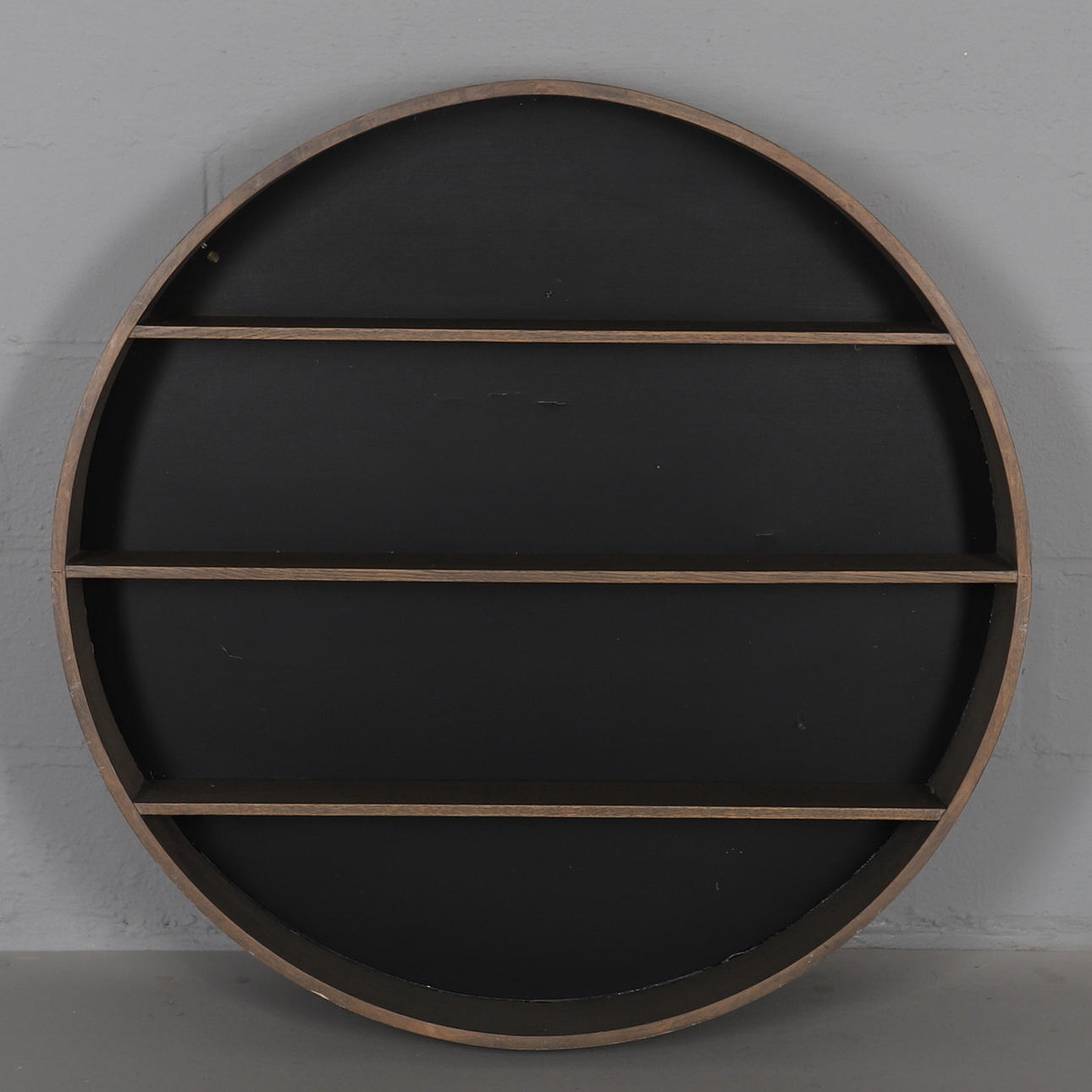 EN CIRKULÄR HÄNGANDE VÄGGHYLLA.
