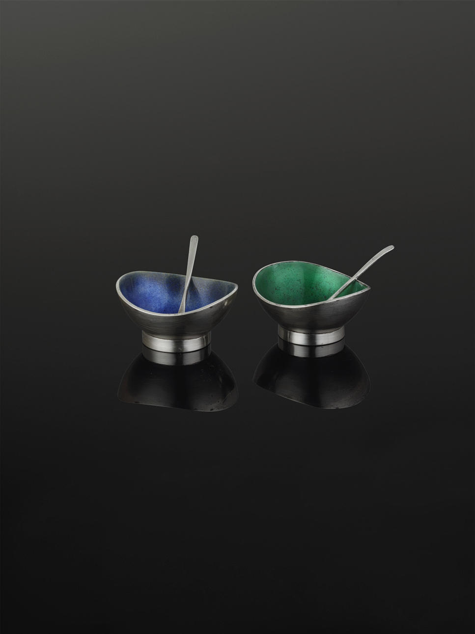 REY URBAN. ETT PAR SALTKAR, sterling silver varav den ena med blå emalj och den andra med grön emalj, samt två saltskedar.