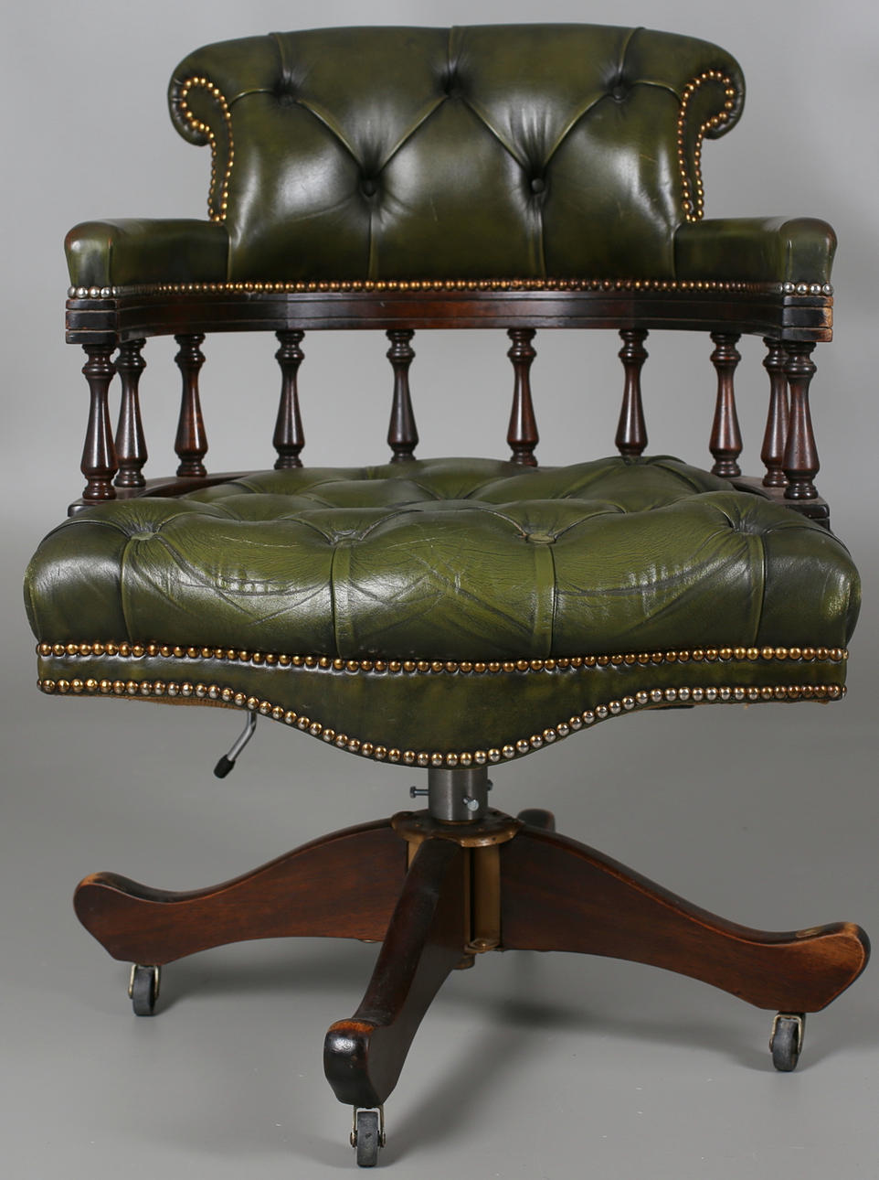 SNURRFÅTÖLJ i grönt skinn i engelsk stil. 1900-talets senare del.