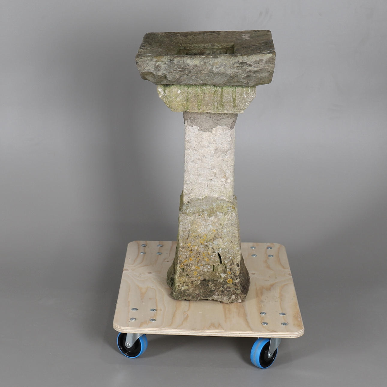 UN PEDESTAL DE JARDÍN RÚSTICO DE PIEDRA RECONSTITUIDO.