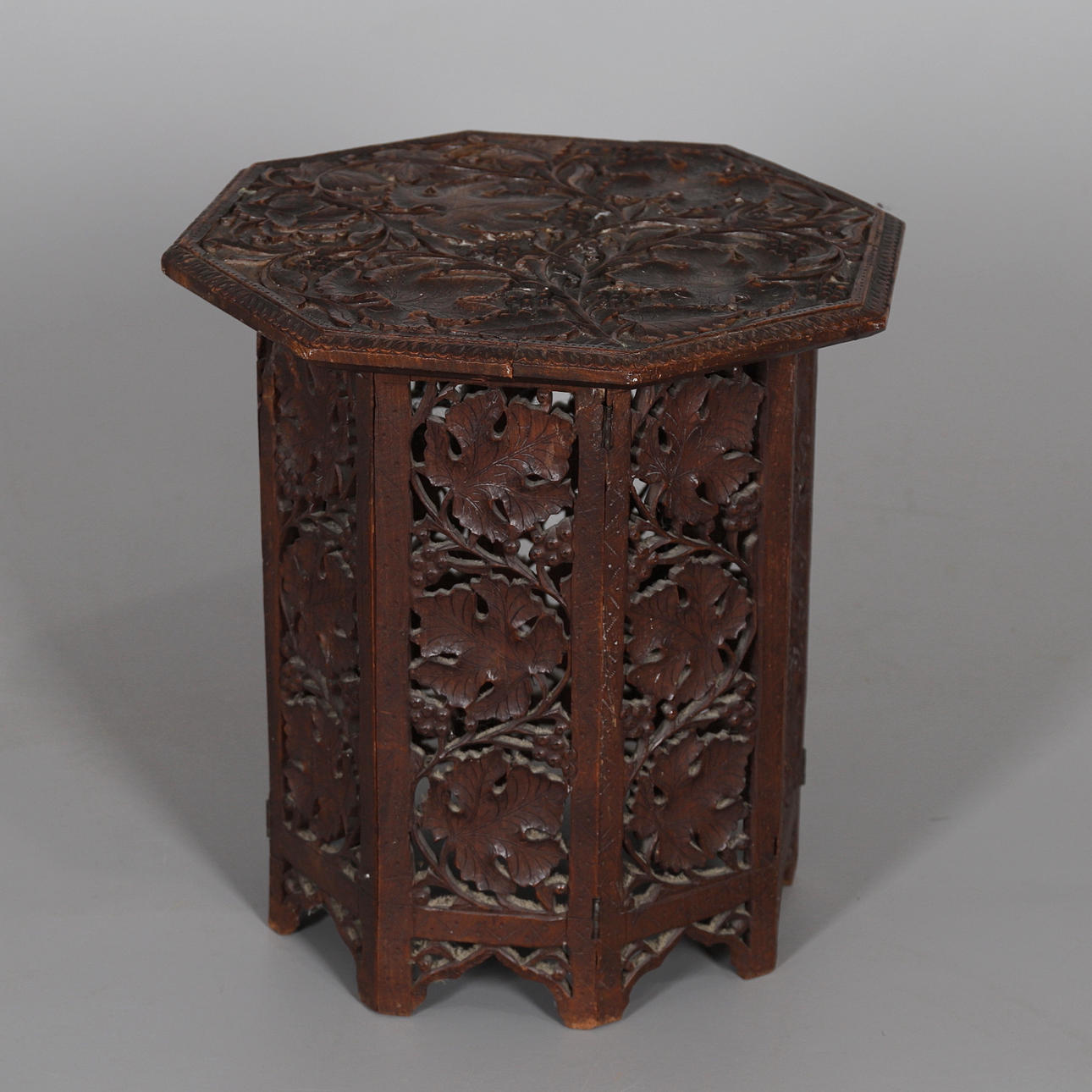 ET INDISK UDSKåret BORD I HÅRDTRÆ.