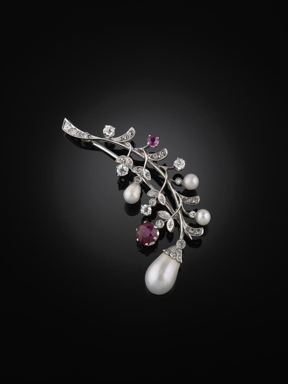 BROSCH, 18 kt vitguld föreställande en kvist med en rubin, små gammalslipade diamanter, rosenstenar, en liten rosa safir, 3 mindre och en större droppformad pärla, ca 10 x 7.5 mm.