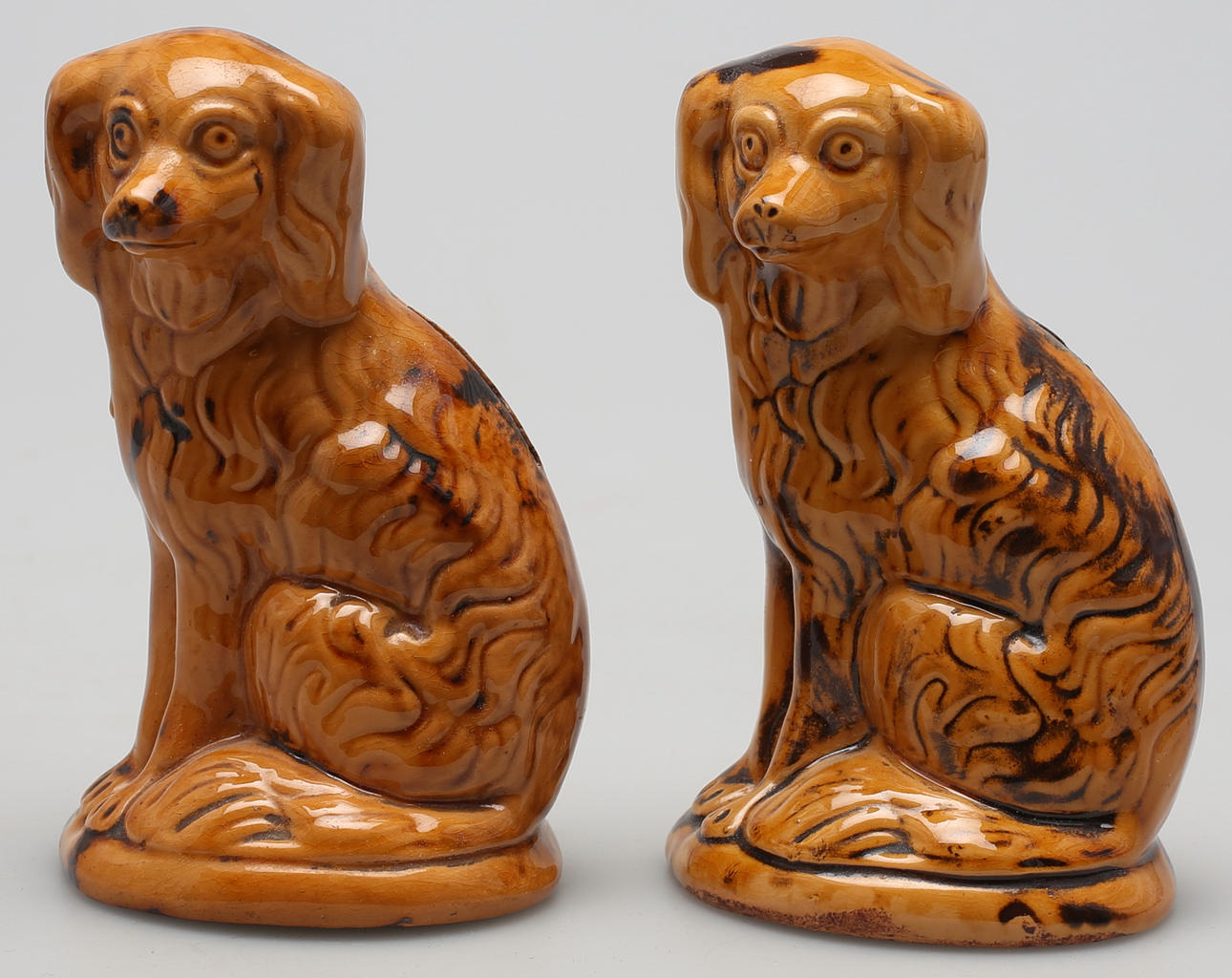 SPARHUNDAR, 2 st i gul/svart glaserat gods. Troligen Höganäs, tidigt 1900-tal.