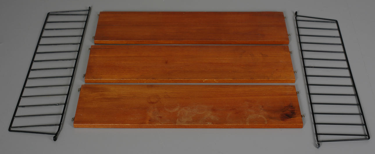 STRINGHYLLA med 3 hyllplan i teakfanér med plastöverdragen ståltrådsgavlar. Design Nils Strinning.