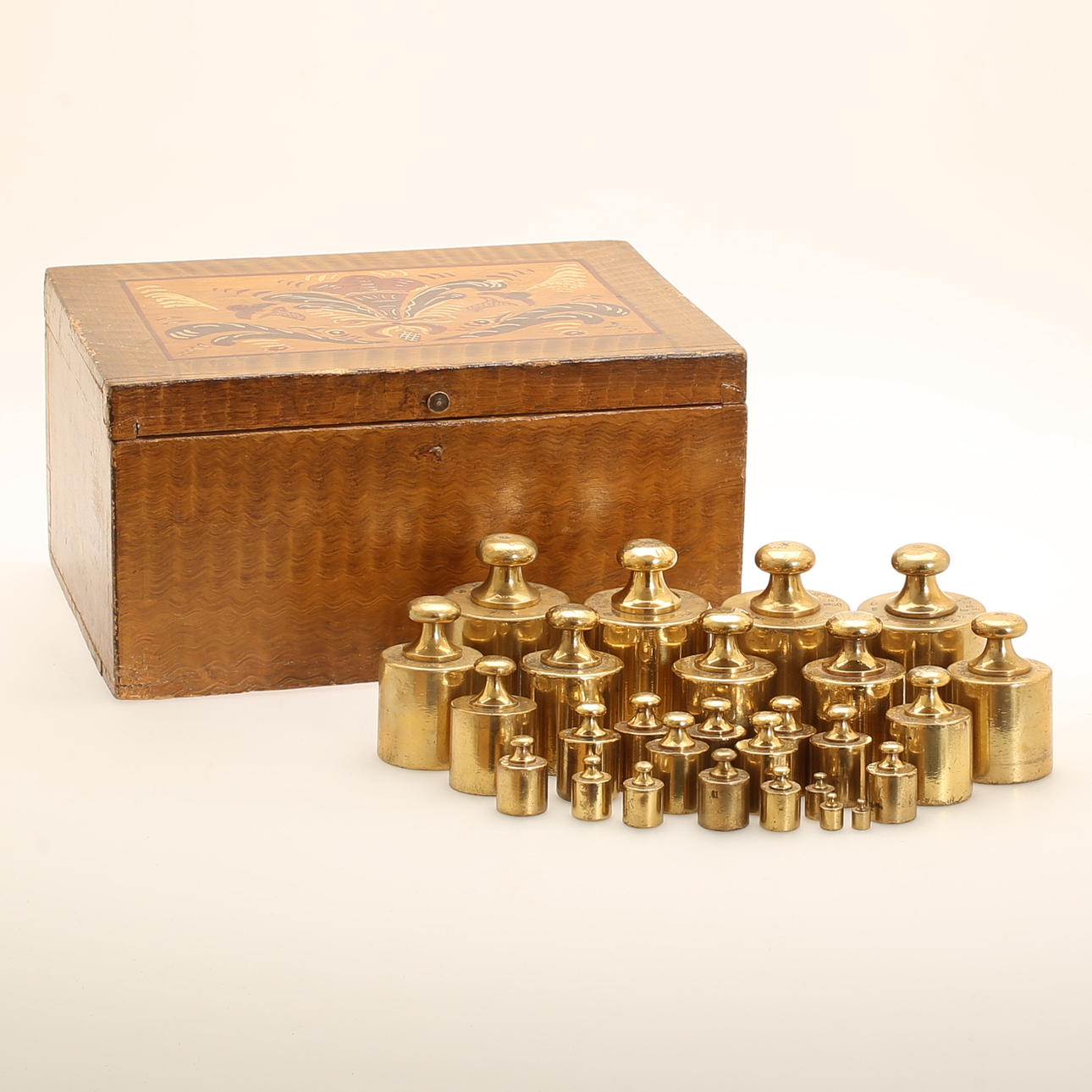 VIKTER, 27 stycken, krönta, mässing. TRÄLÅDA.