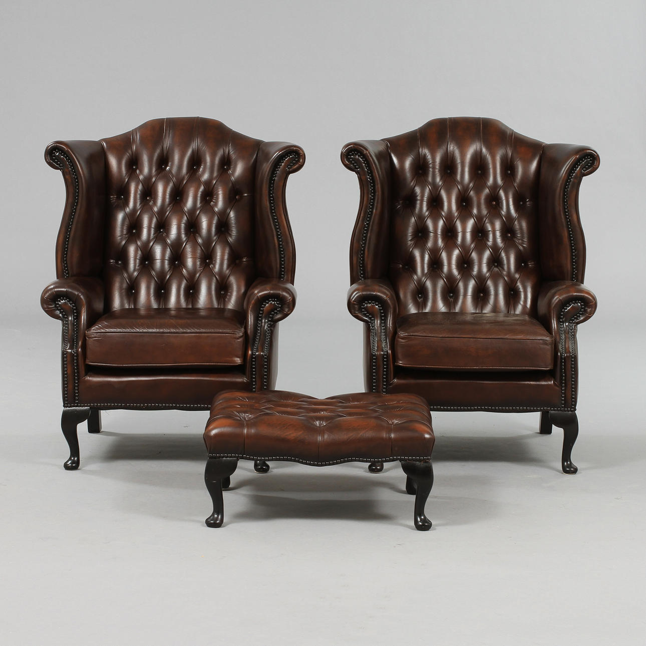 ÖRONLAPPSFÅTÖLJER, ett par, samt FOTPALL, Chesterfieldstil, 1900/2000-tal.