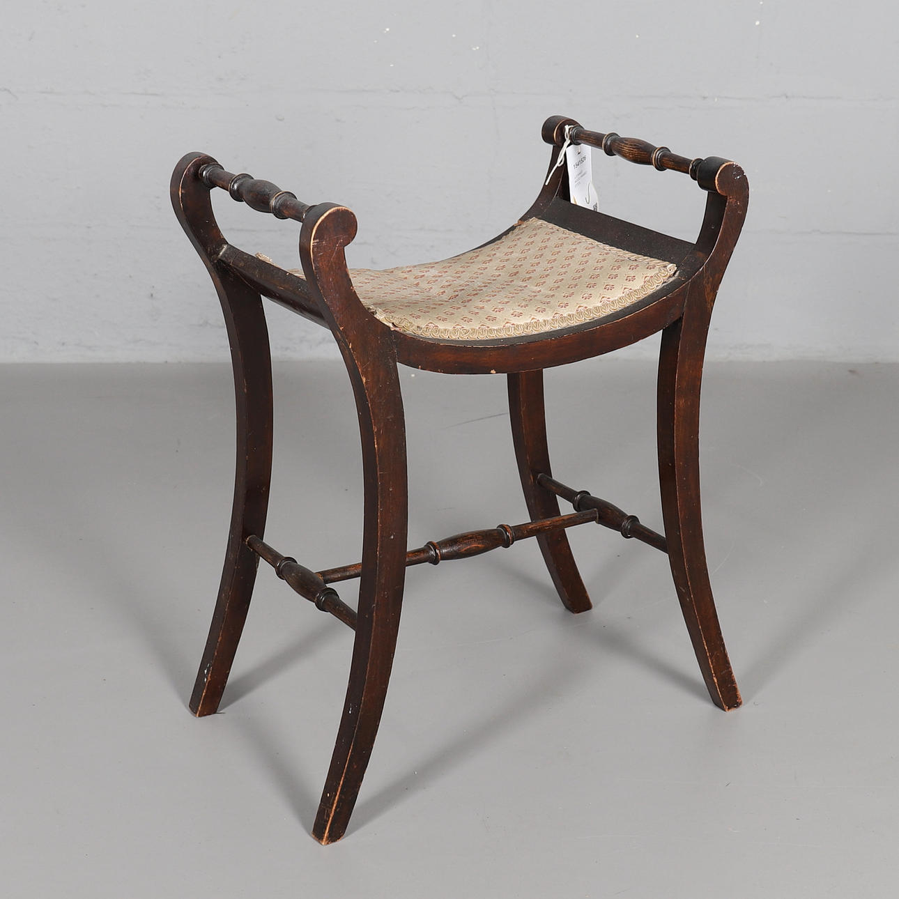 A STAINED WOOD FRAMED STOOL.
