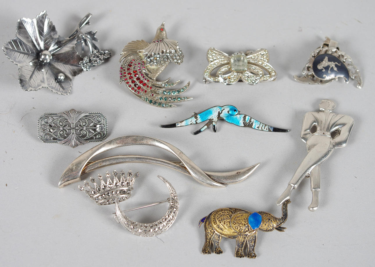 10 BROSCHER SAMT 1 PAR ÖRHÄNGEN.