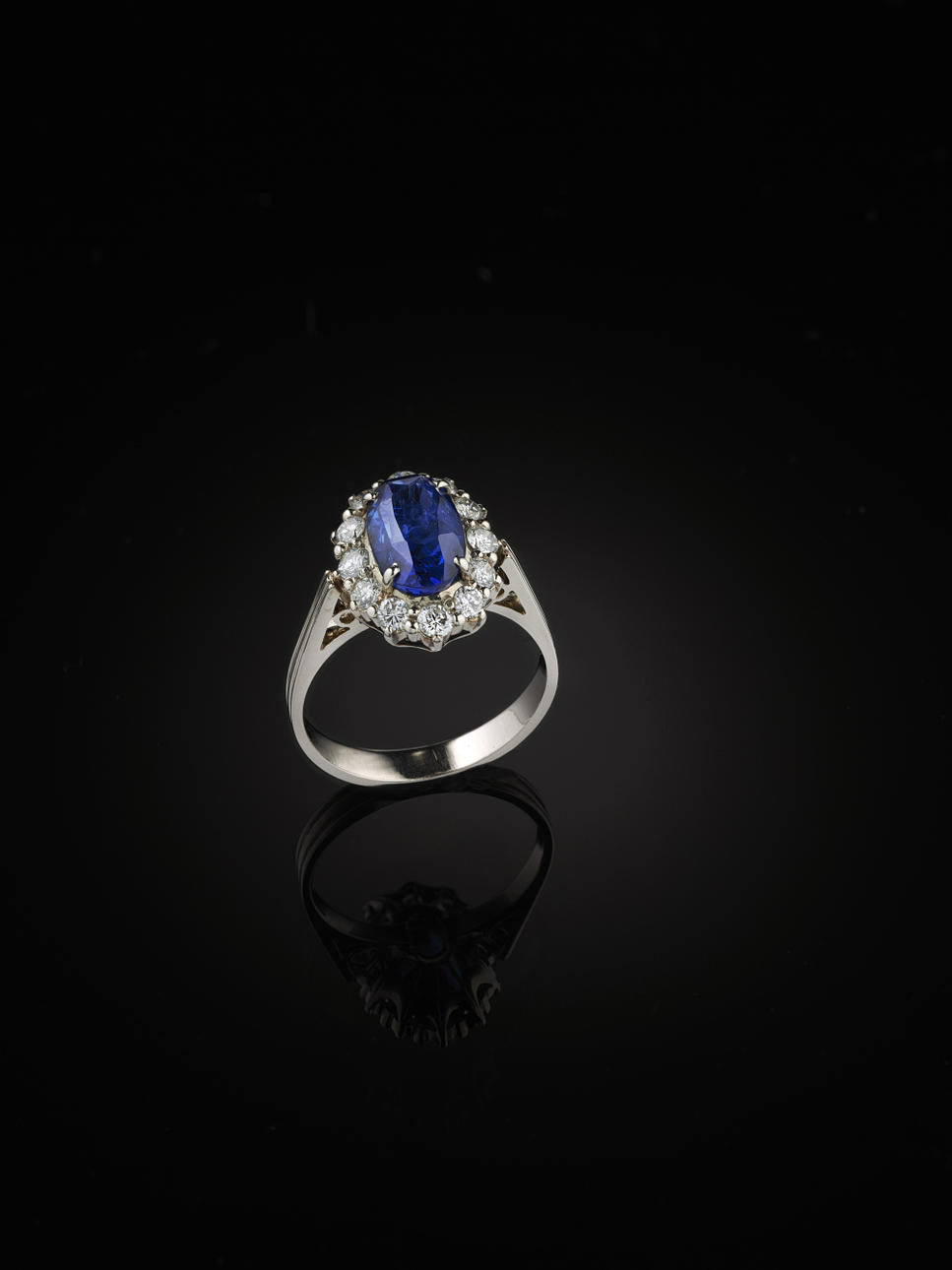 Ring, 14 kt vitguld i karmosemodell med en safir och 12 briljanter ca 0.40 ct.