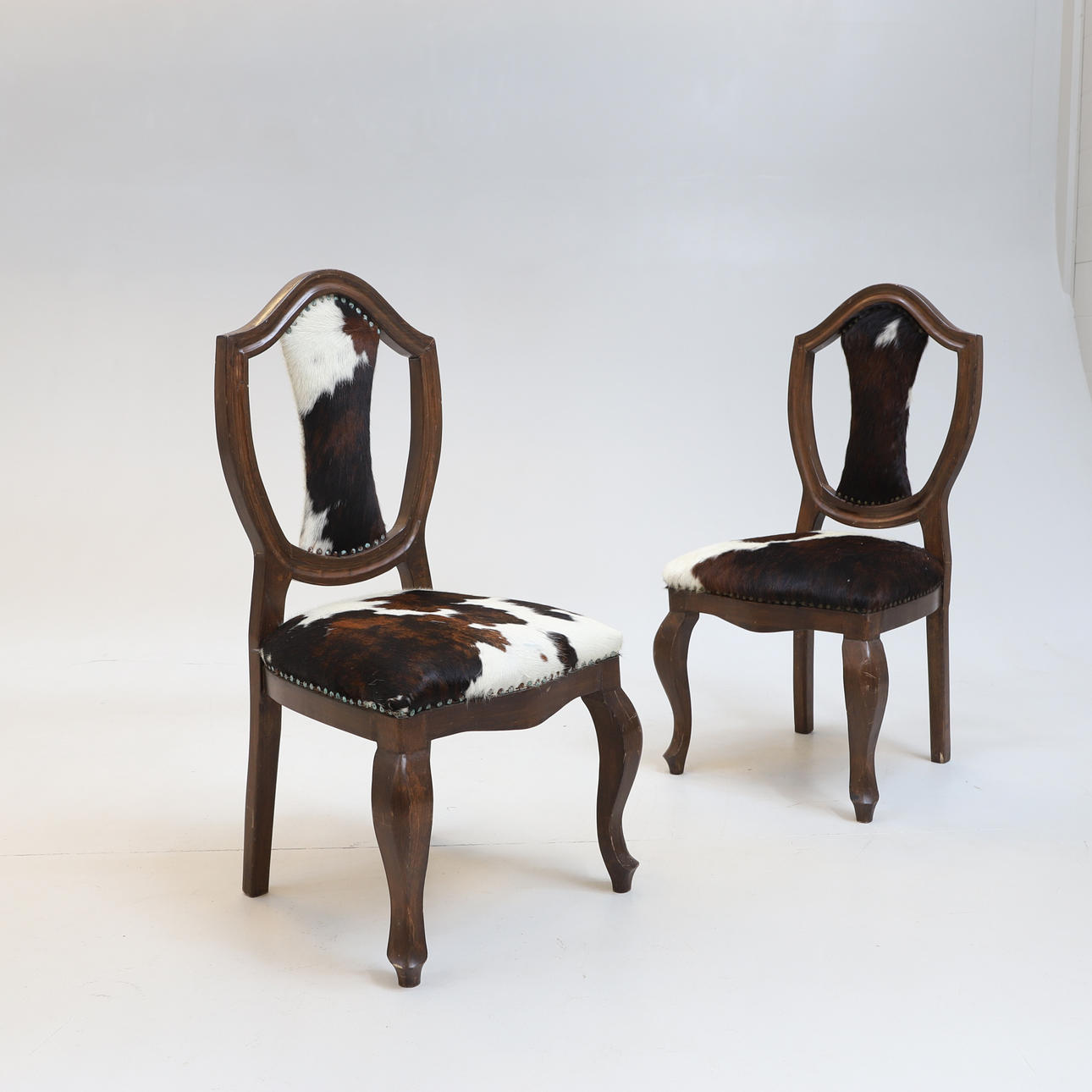 2 SILLAS, madera/piel de vaca, década de 1900.