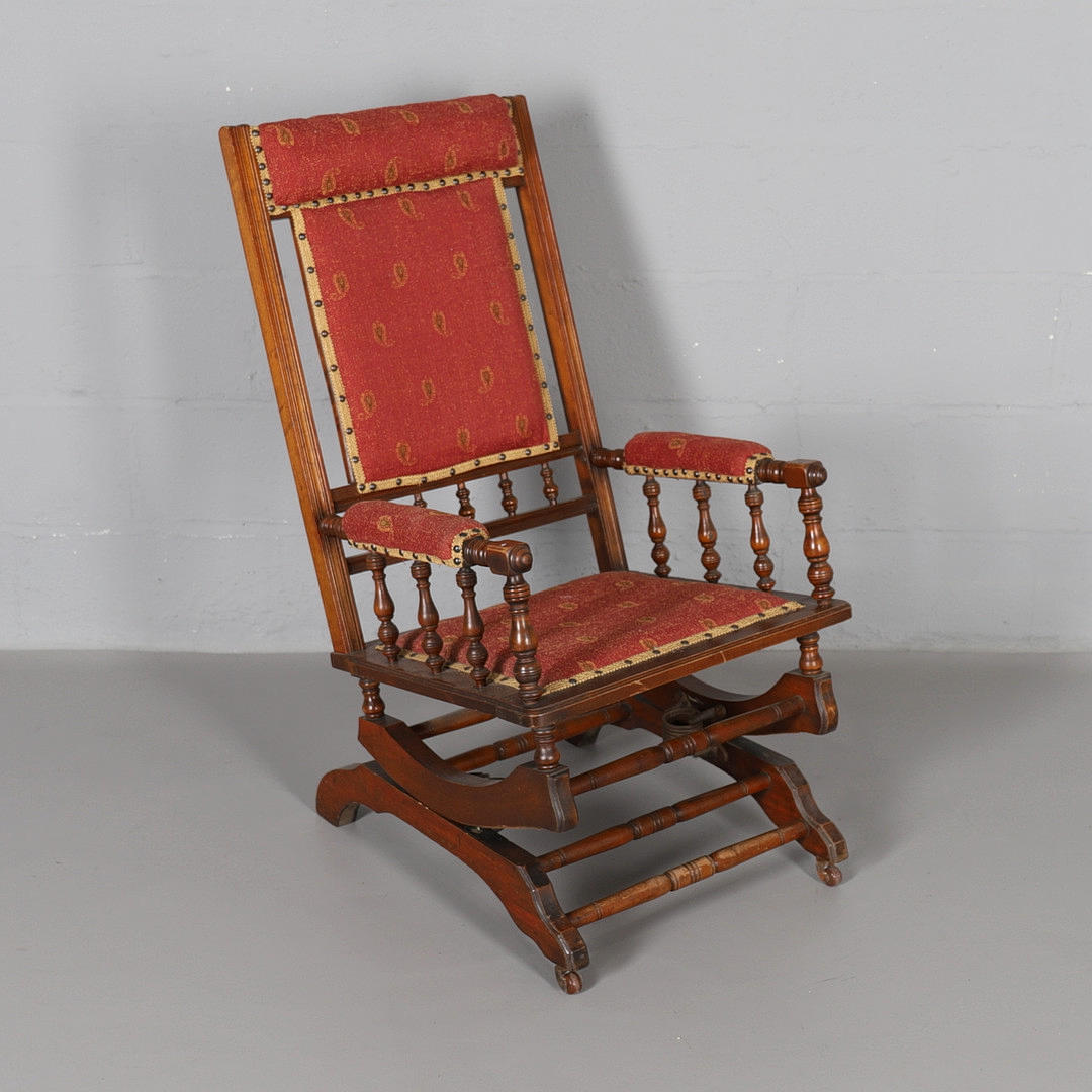 AN EDWARDIAN WALNUT FRAME ROCKING CHAIR.