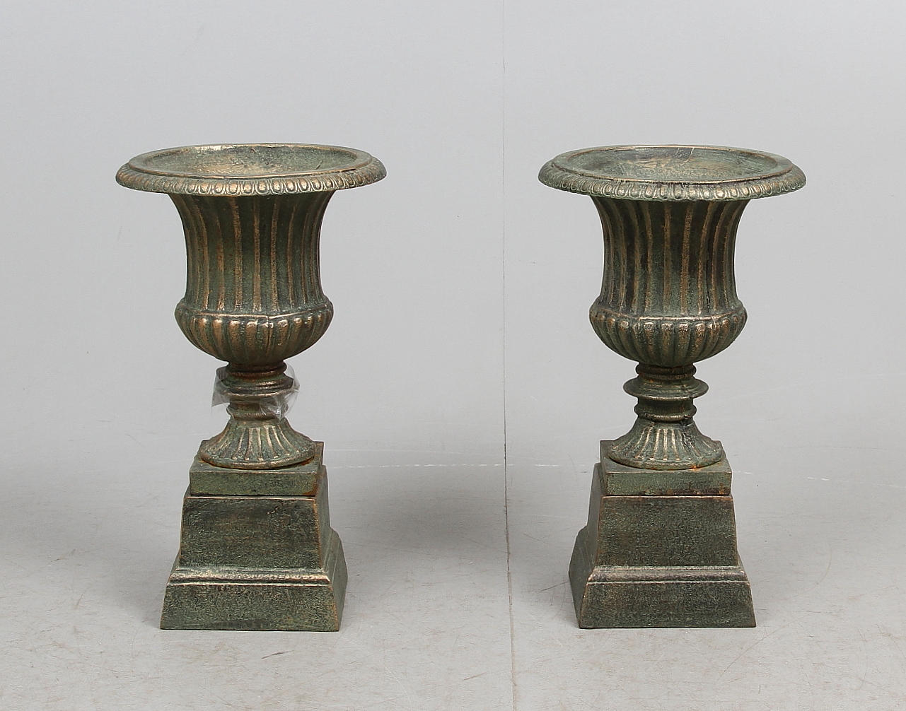 TRÄDGÅRDSURNOR, ett par, på sockel, kopparfinish, 2000-tal.