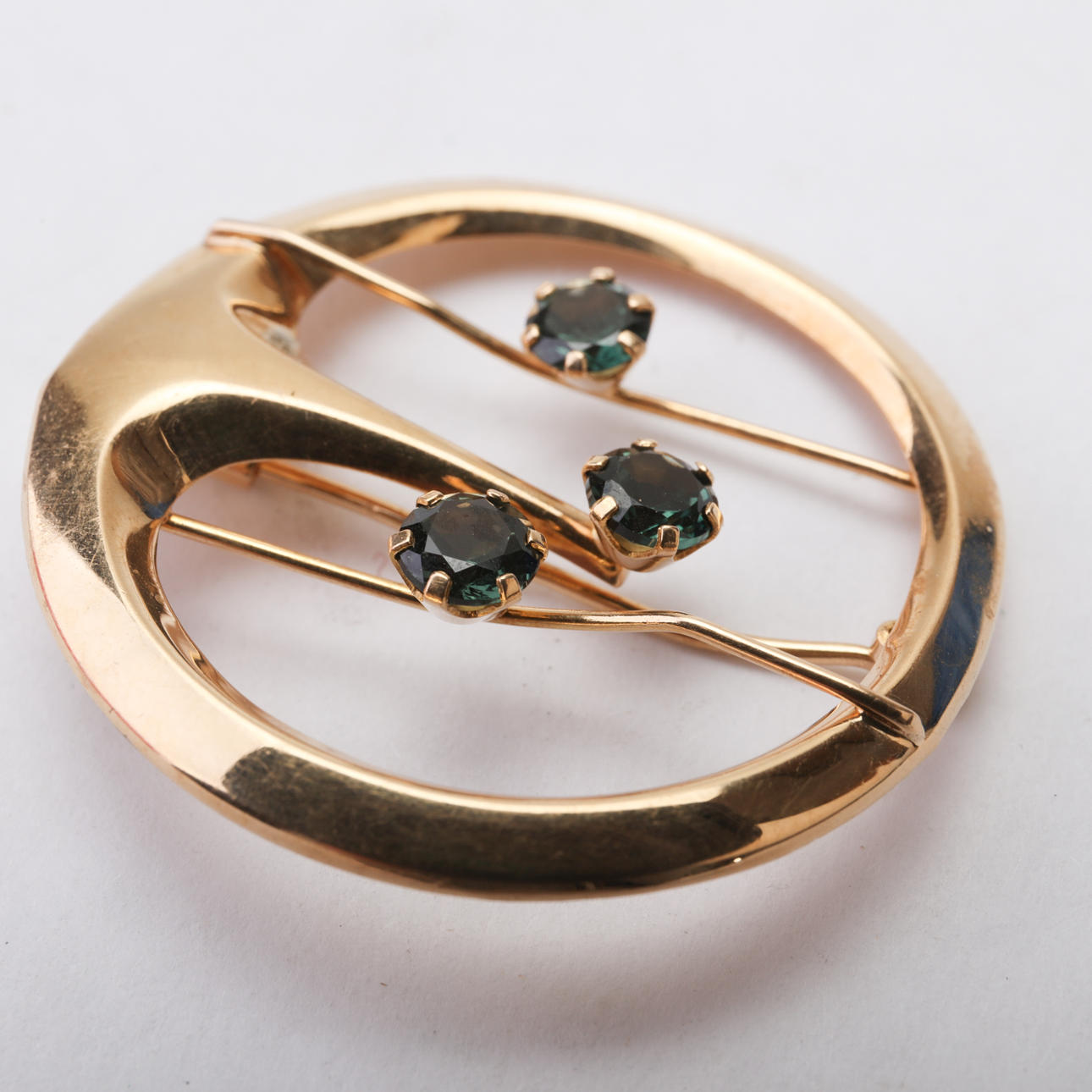 BROSCHE, 18 Karat, drei grüne Steine.