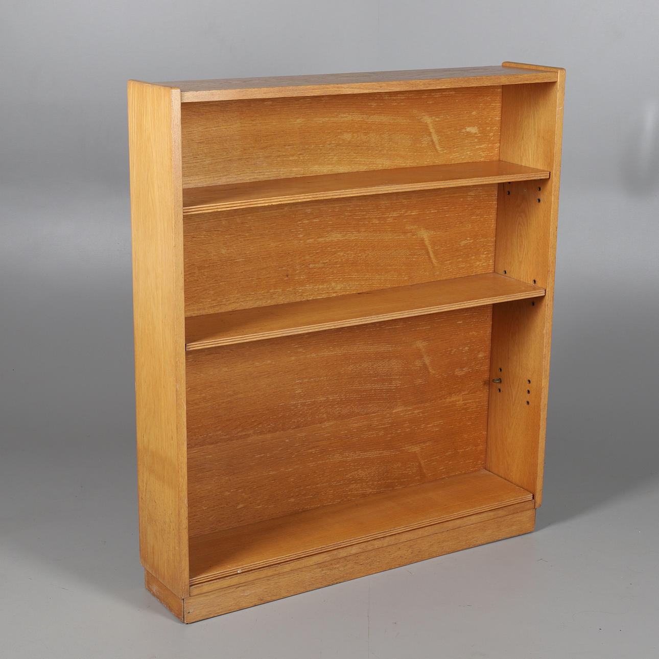 A MID-CENTURY OAK OPEN BOOKCASE.