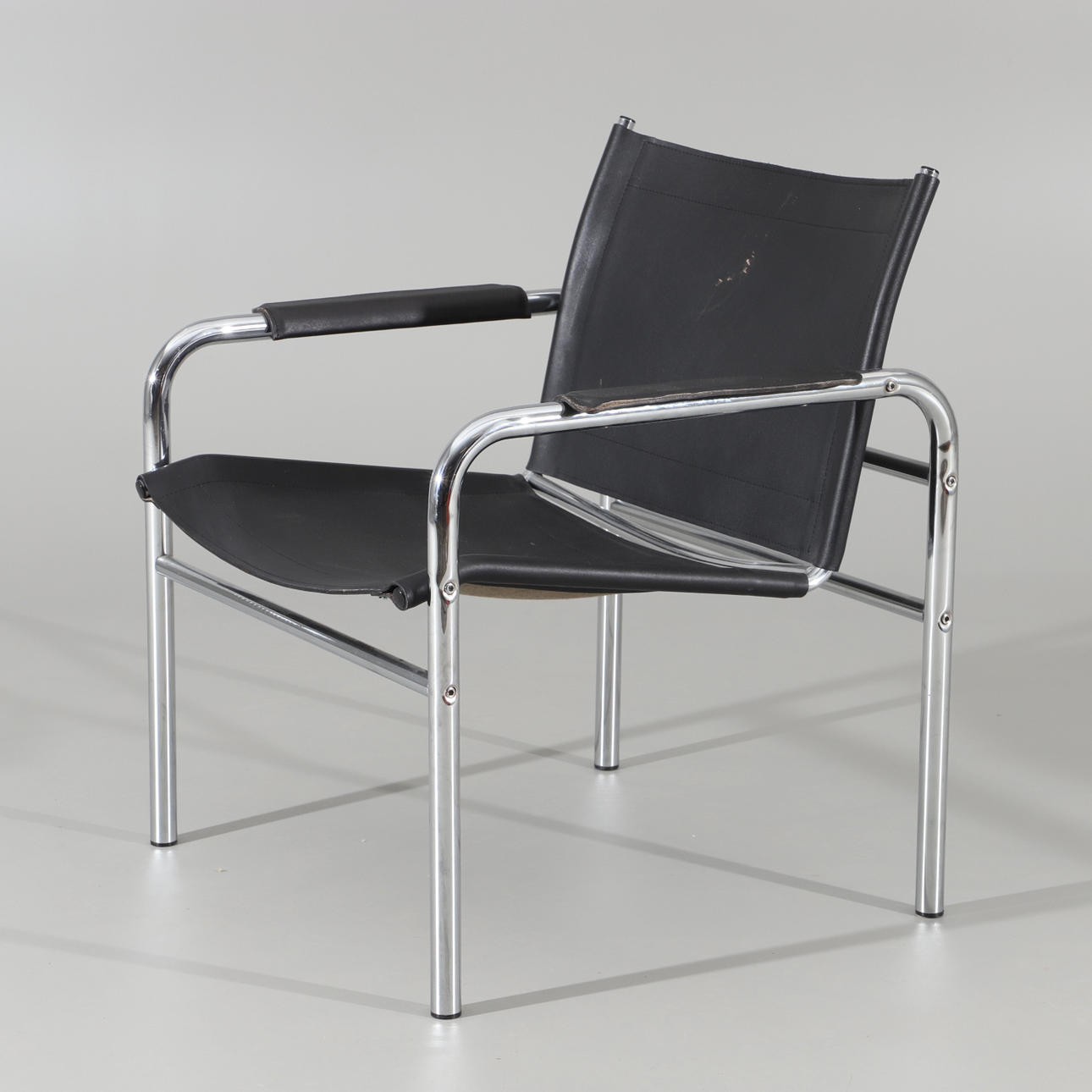 TORD BJORKLUND. Sillón, "Klinte", cuero negro con base cromada.