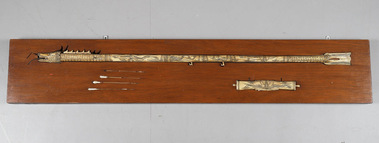 EIN INDONESISCHES SCHNITT-BLASROHR AUS KNOCHEN, MODELLIERT ALS DRACHE.