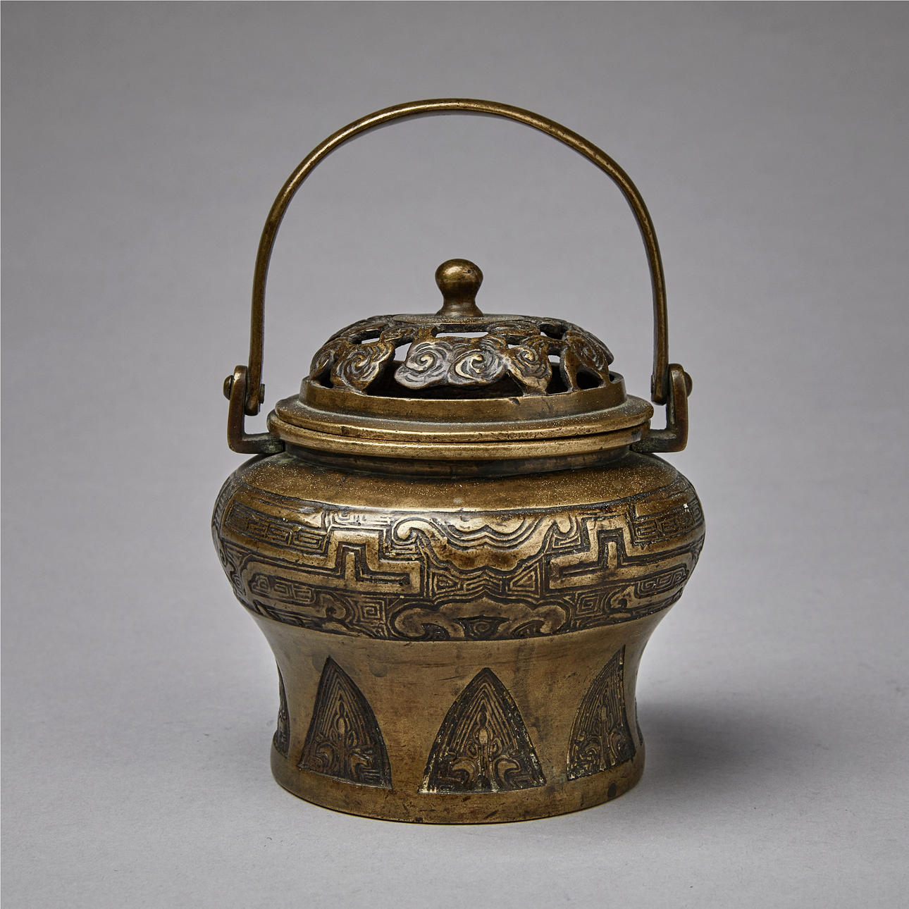 Pronssinen käsilämmitin.