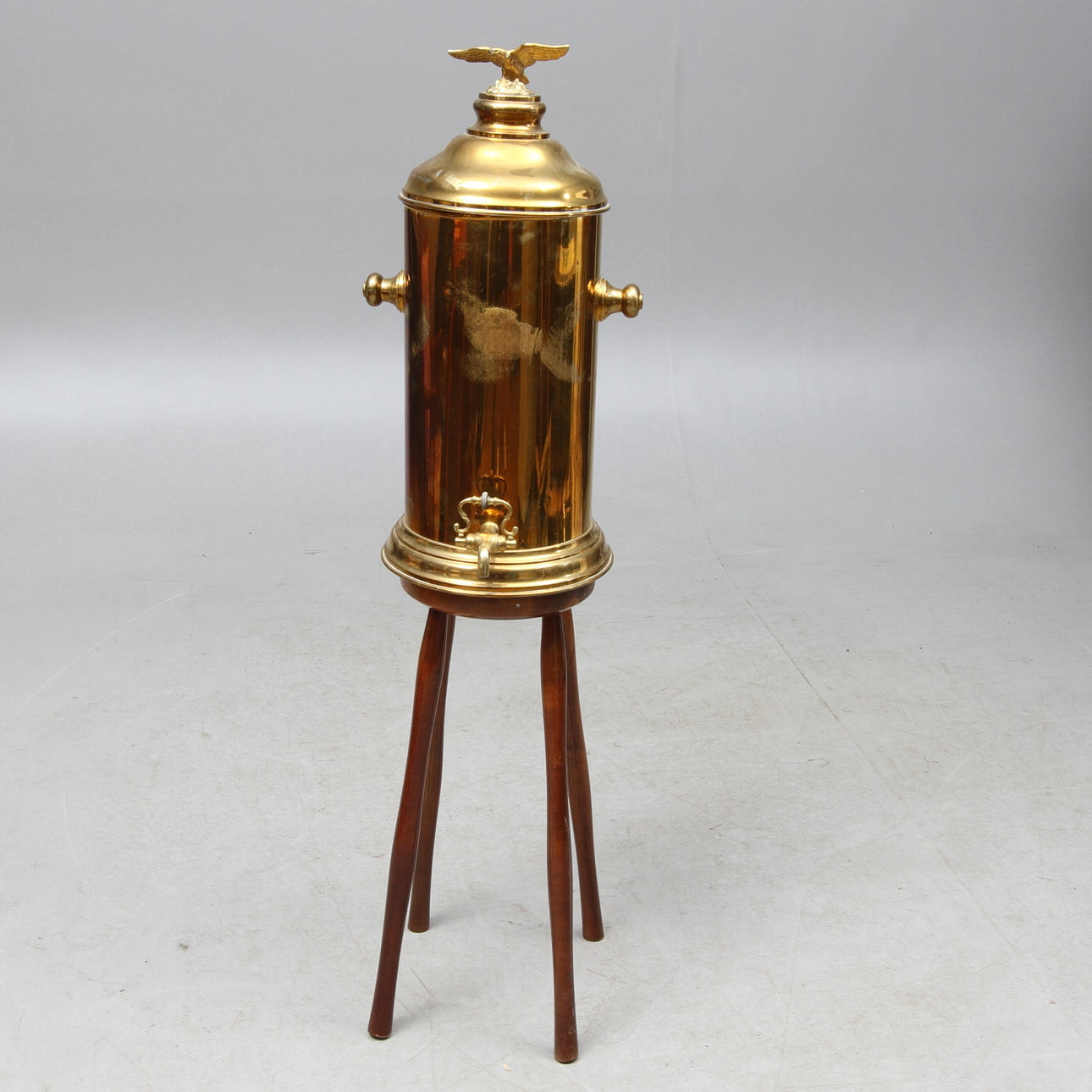 BEHÅLLARE MED TAPP på benställning, mässing, 1900-tal.