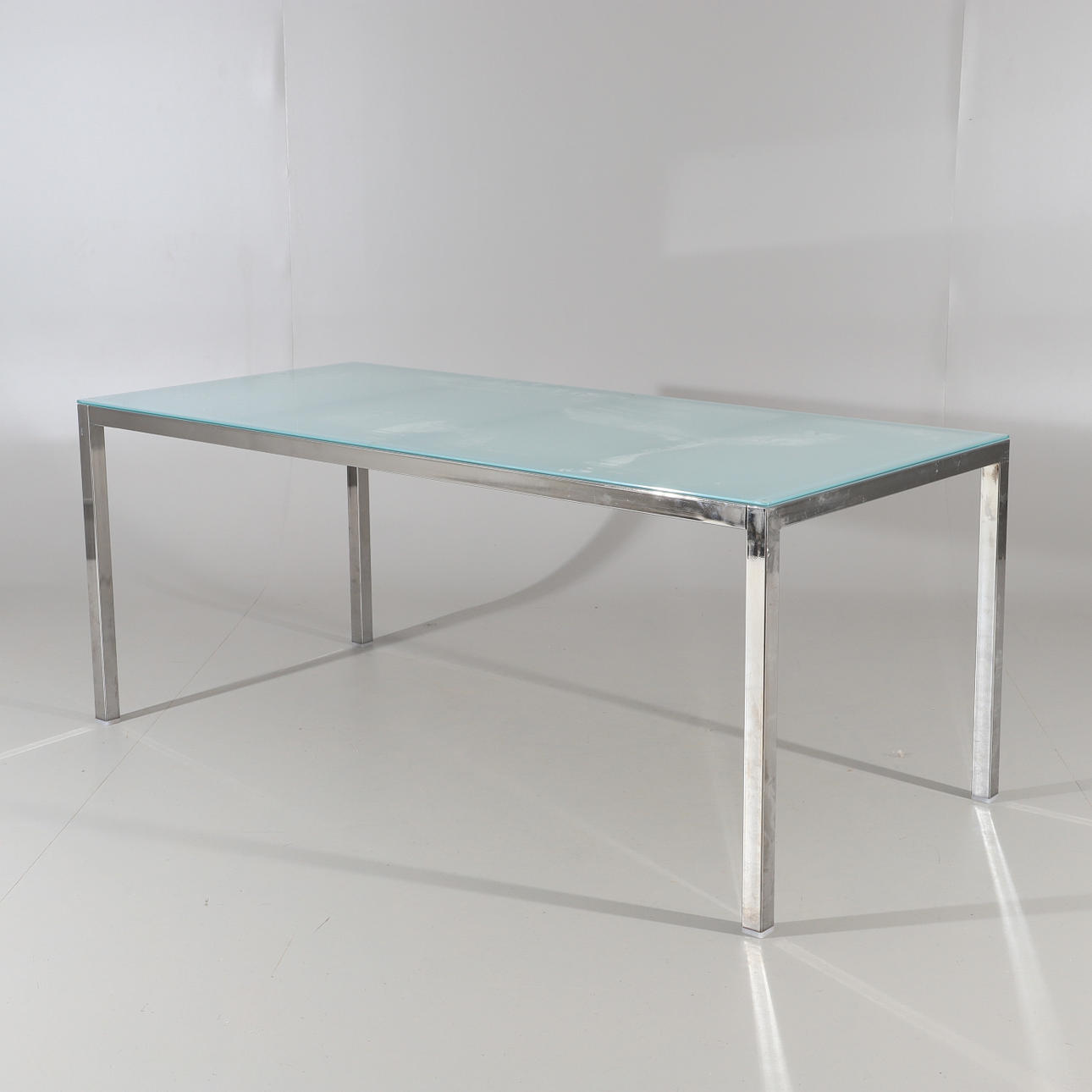 DINING TABLE, glass top with chrome base, 2000s.