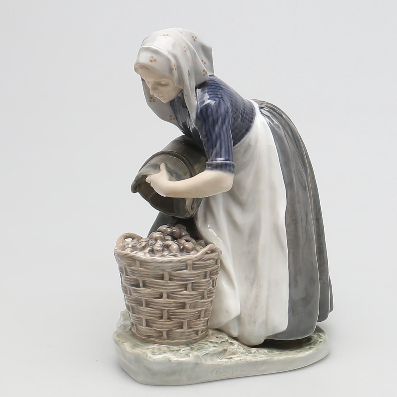 FIGURIN i porslin. "Kvinna med potatiskorg". Royal Copenhagen, Danmark.