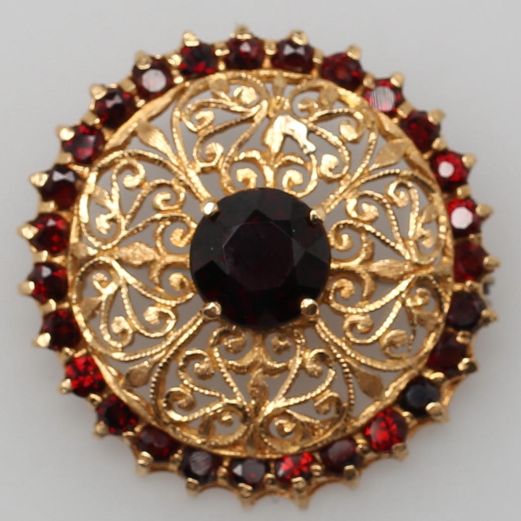 BROSCH i guld. 18 K. Filigranarbete, besatt med granater.